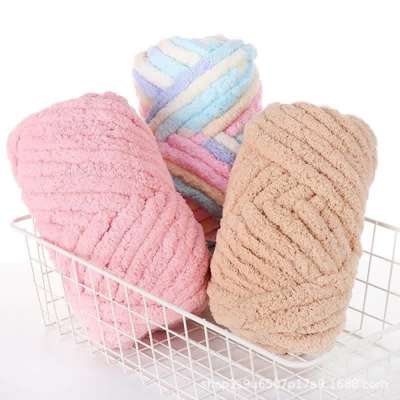 Pink, tan, and pastel multi-colored chunky yarn skeins resting in a white wire basket.